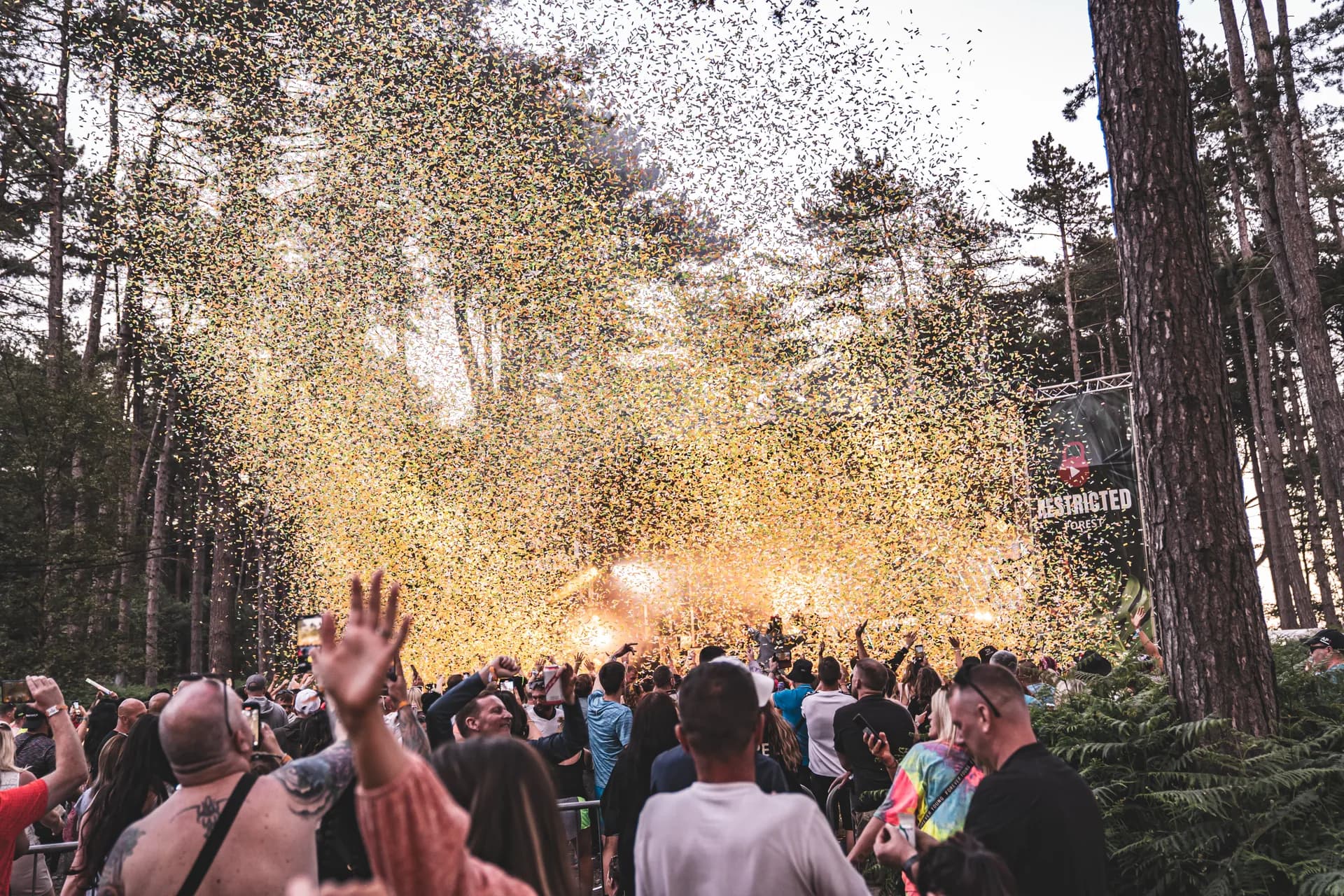 Confetti cannon firing over the crowd, canopy above.