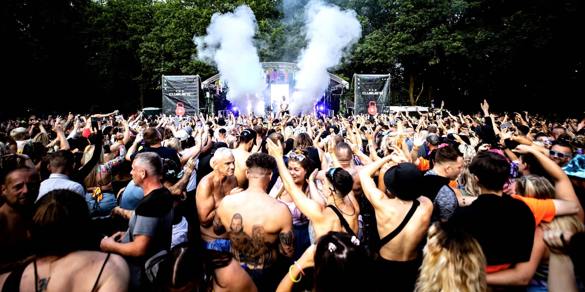 White CO2 jets firing from the cog stage over the crowd in daylight.