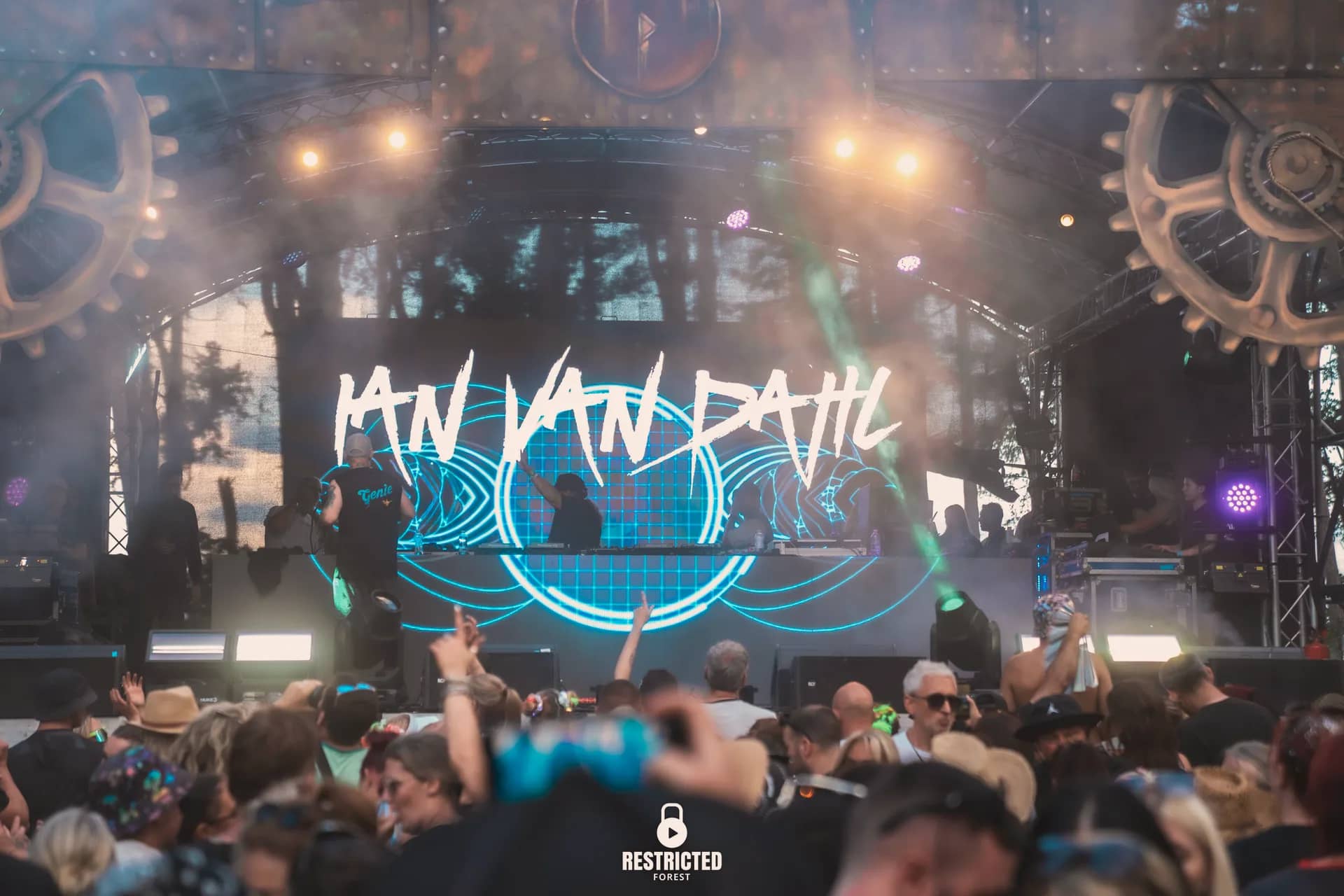 The Factory stage at night, the headline name in blue on the screen under the arch, the crowd silhouetted in front. Source frame RestrictedForest2026-1681.